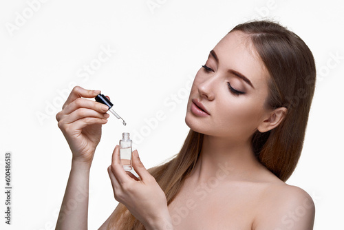 beautiful woman holding bottle with serum for skin care