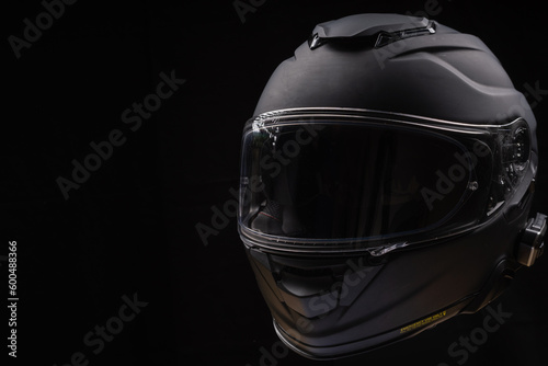 Black motorcycle helmet on dark background, space for text  © Marek