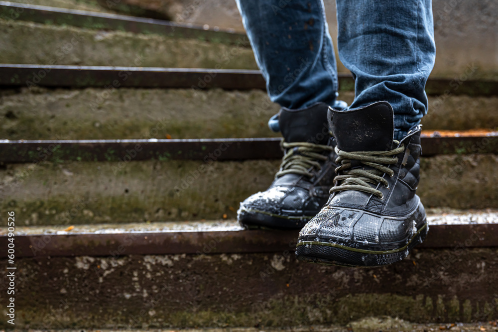 A man in boots on the old steps, close-up. A man in boots on the old steps, close-up.