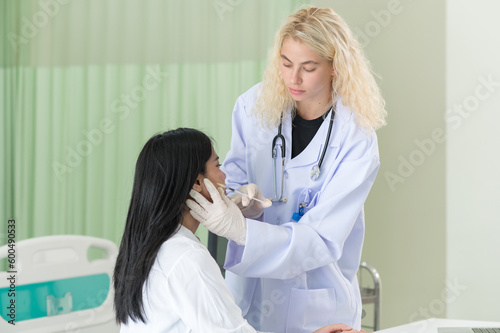 Woman doctor cosmetologist injects a filler into the cheek of the patient's woman. Cosmetology concept.