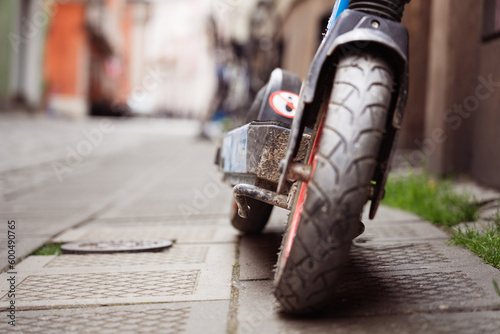 Close-up of the wheel of an electric scooter parked in the center of the old town.