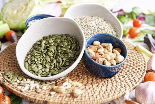 Close-up, a bowl of pumpkin seeds and other healthy foods on the kitchen table.