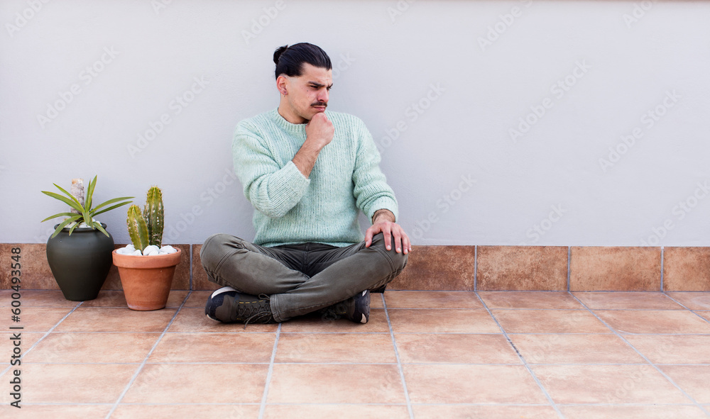 young handsome man gardering and sitting on the floor outdoors