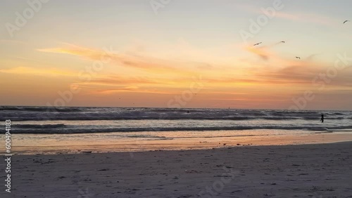 Lovely sunset glow on clouds with birds fly at beach silhouette photo