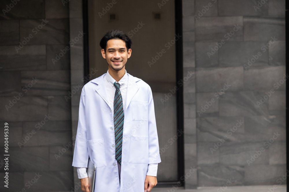 Cheerful Asian young man doctor posing and smiling looking at camera. healthcare and medicine Cheerful Asian young man doctor posing and smiling looking at camera. healthcare and medicine