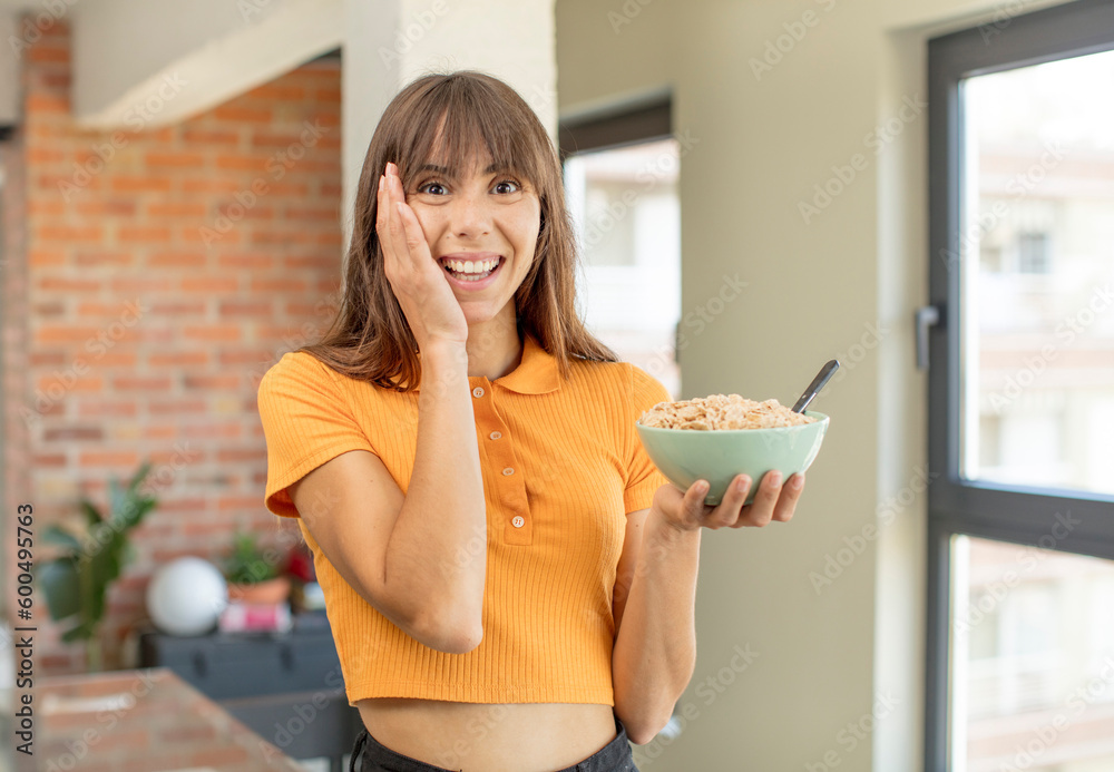 young pretty woman feeling happy and astonished at something unbelievable. breakfast bowl concept