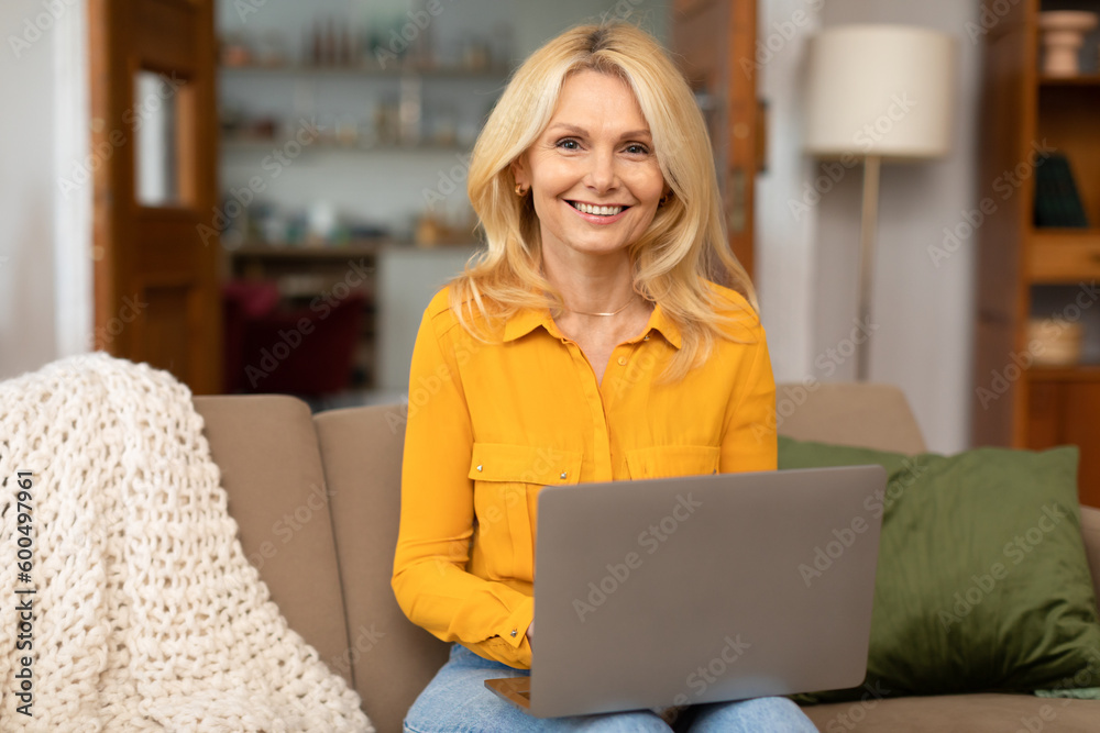 Cheerful Mature Lady Using Laptop Smiling To Camera At Home
