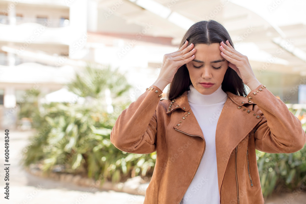 pretty young adult woman looking concentrated, thoughtful and inspired, brainstorming and imagining with hands on forehead