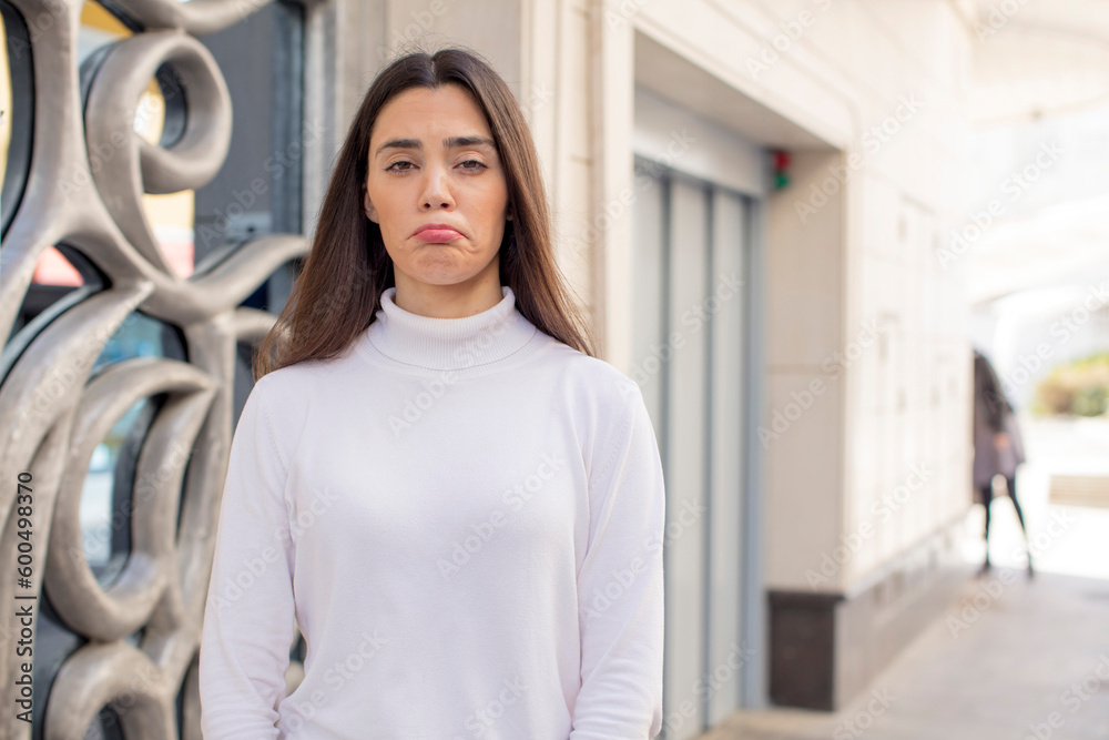 pretty young adult woman feeling sad and whiney with an unhappy look, crying with a negative and frustrated attitude