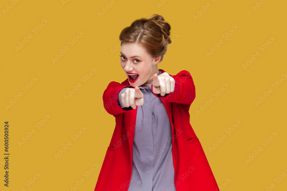 Portrait of excited flirting woman with red lips standing pointing at you, looking at camera with positive expression, wearing red jacket. Indoor studio shot isolated on yellow background. Portrait of excited flirting woman with red lips standing pointing at you, looking at camera with positive expression, wearing red jacket. Indoor studio shot isolated on yellow background.