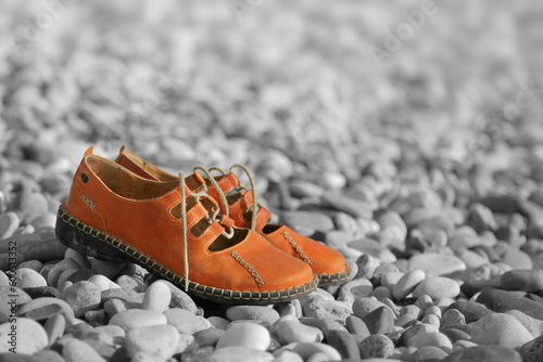 pair sandals on a pebbled beach