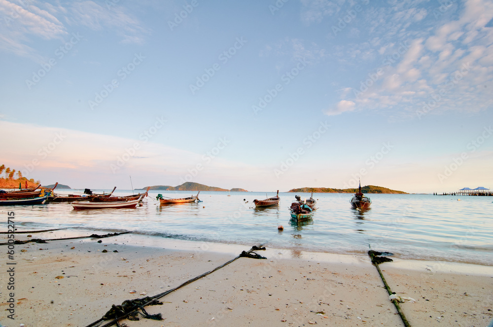 A view on a beach with longboats docked in the bay.