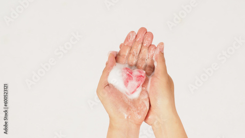 Hands washing with foaming and pink soap on white background. Studio shot
