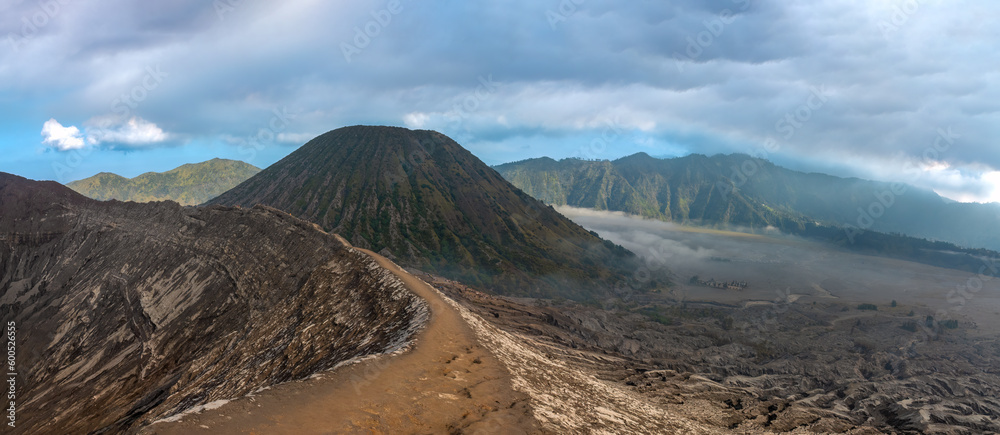 Hiking trail along the edge of Mount Bromo's crater with Mount Semeru, Mount Batok and the Sea of Sand (Segara Wedi) in the background, East, Java, Indonesia