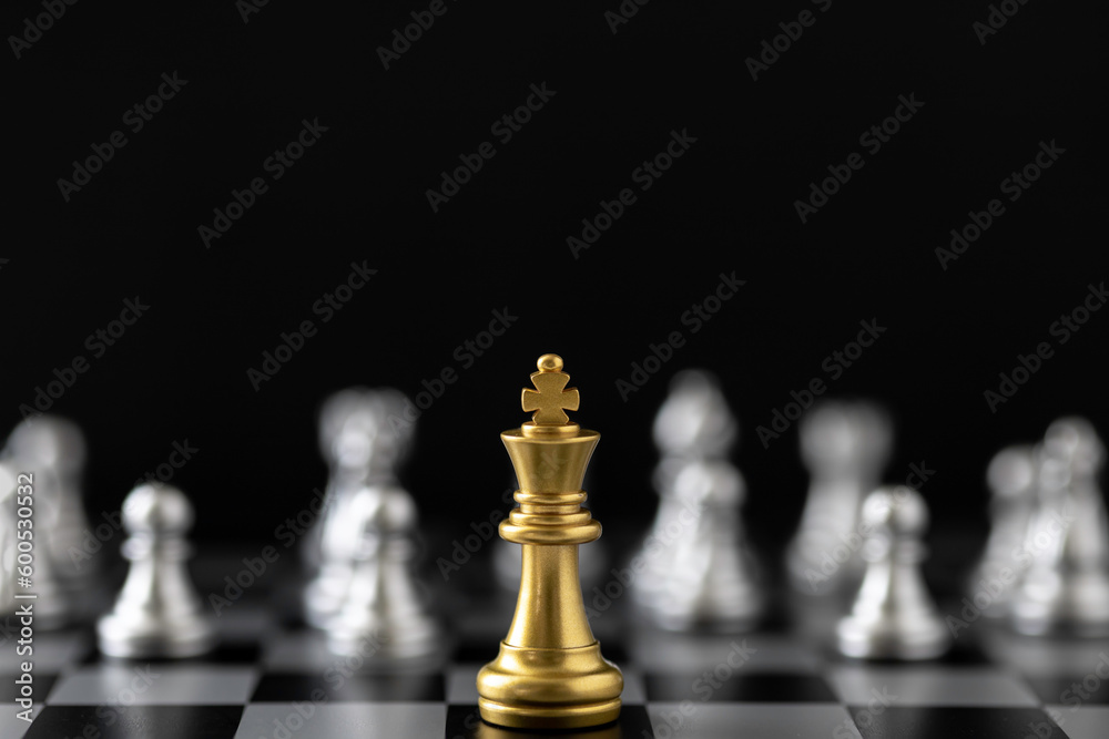 Golden King chess standing in front of other chess on chess board. Golden King chess standing in front of other chess on chess board.