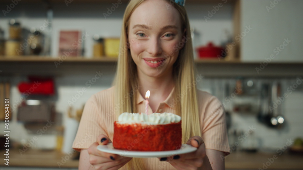 Girl holding cake smiling on laptop web camera closeup. Girl blowing on candle.