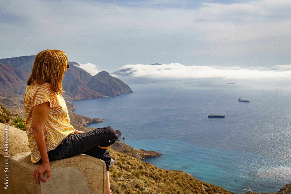 Woman contemplating the Mediterranean sea from the top of the hill