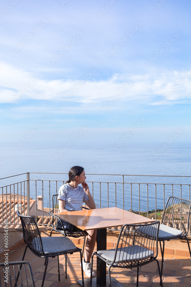 real woman relaxing in a cafe in front of the sea