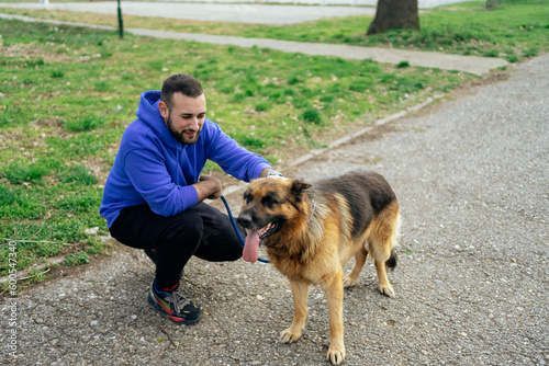 Young Man Petting his Dog in Public Park