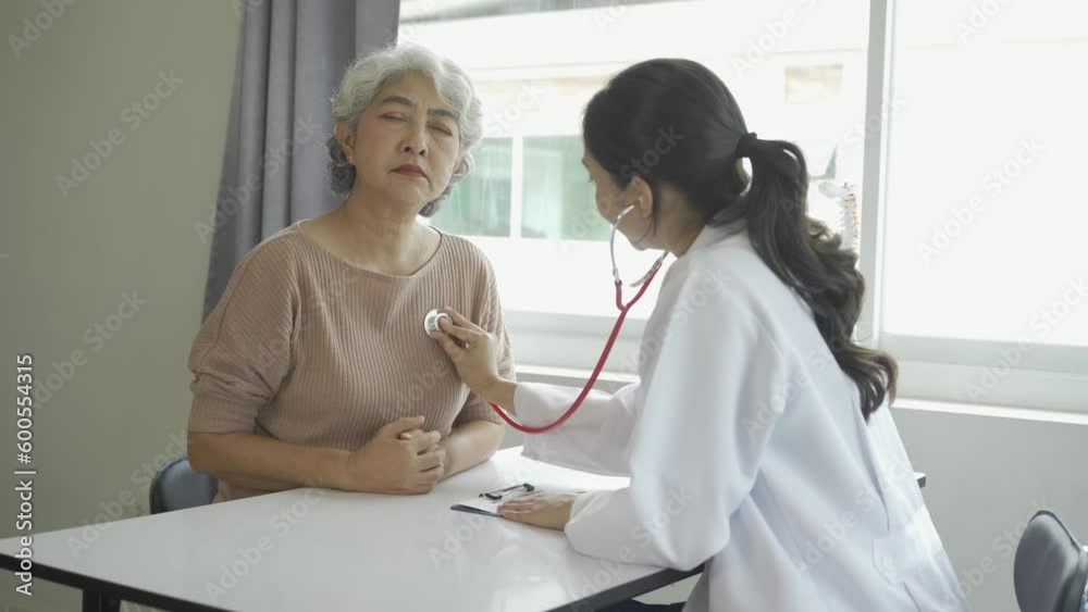 Female doctor using stethoscope to check lungs and heart rate of elderly female patient at hospital Talk therapy is encouraging, medical health concept. Female doctor using stethoscope to check lungs and heart rate of elderly female patient at hospital Talk therapy is encouraging, medical health concept.