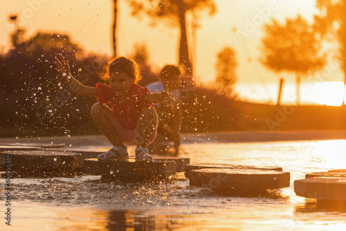 Children playing at water park on a hot summer sunset day