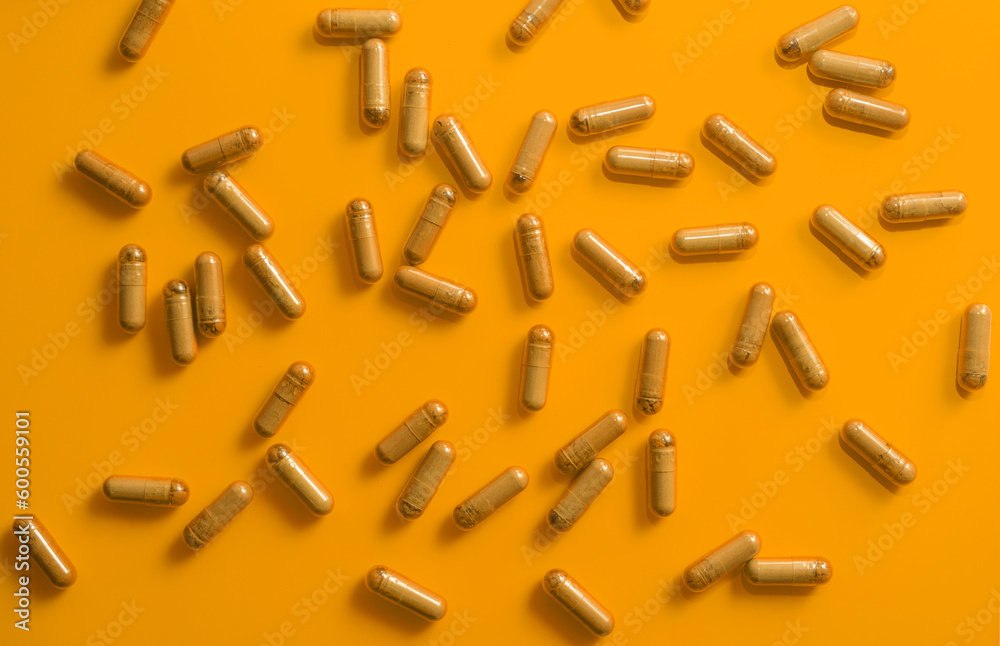 kratom pills random composition on orange background