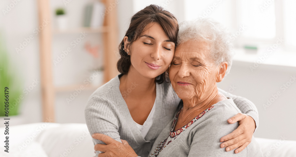 Happy elderly woman with her daughter at home - obrazy, fototapety, plakaty 