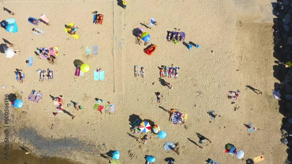 Aerial top down view of the beach with people resting on sun loungers and with beach umbrellas Aerial top down view of the beach with people resting on sun loungers and with beach umbrellas