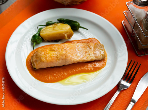 Plate of tasty fish dish - slice of roasted salmon with bell peppers and potato. High quality photo