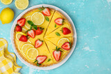Lemon tart decorated with fresh strawberries and citrus slices. Summer healthy dessert. Top view