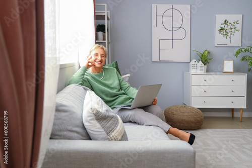 Mature woman with laptop on...