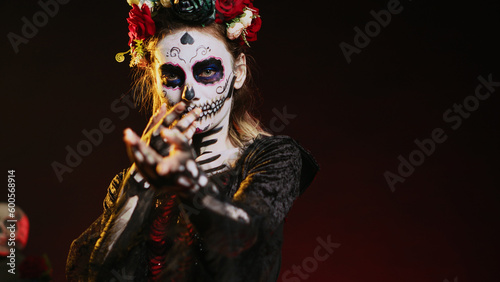 Flirty goddess of dead calling and luring victims, looking like la cavalera catrina with skull black and white make up. Holy santa muerte costume on mexican holiday horror celebration. Handheld shot.