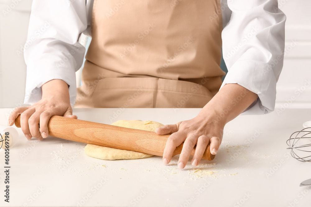 Woman rolling out dough for Italian Grissini at white table in kitchen Woman rolling out dough for Italian Grissini at white table in kitchen