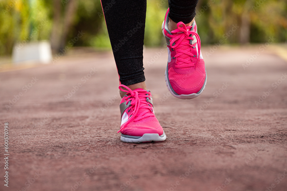Fitness woman training and jogging in summer park, close up on running shoes in sunlight. Healthy lifestyle Fitness woman training and jogging in summer park, close up on running shoes in sunlight. Healthy lifestyle