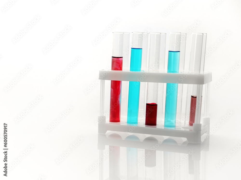 Laboratory test glass tubes with red and blue liquid in stack. Closeup