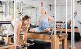 Gym woman pilates stretching sport in reformer bed