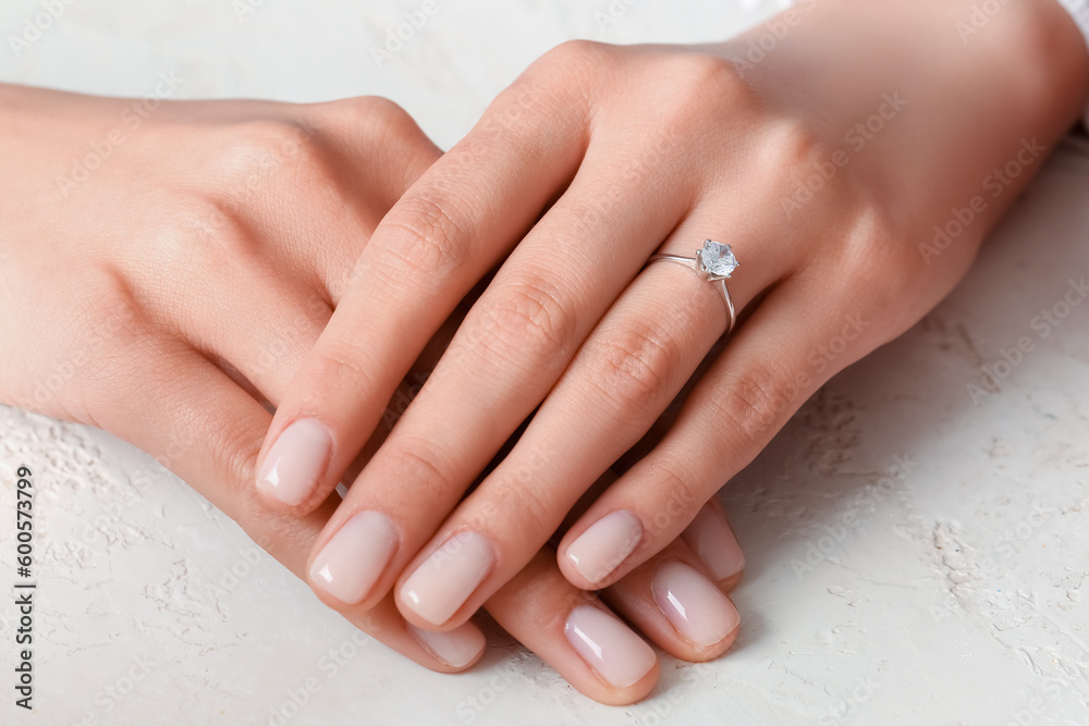 Woman with engagement ring on white background, closeup