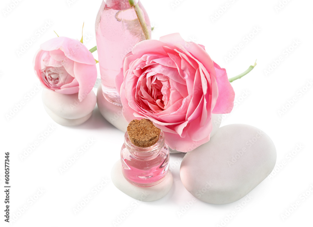 Bottles of cosmetic oil with rose extract and flowers on white background Bottles of cosmetic oil with rose extract and flowers on white background