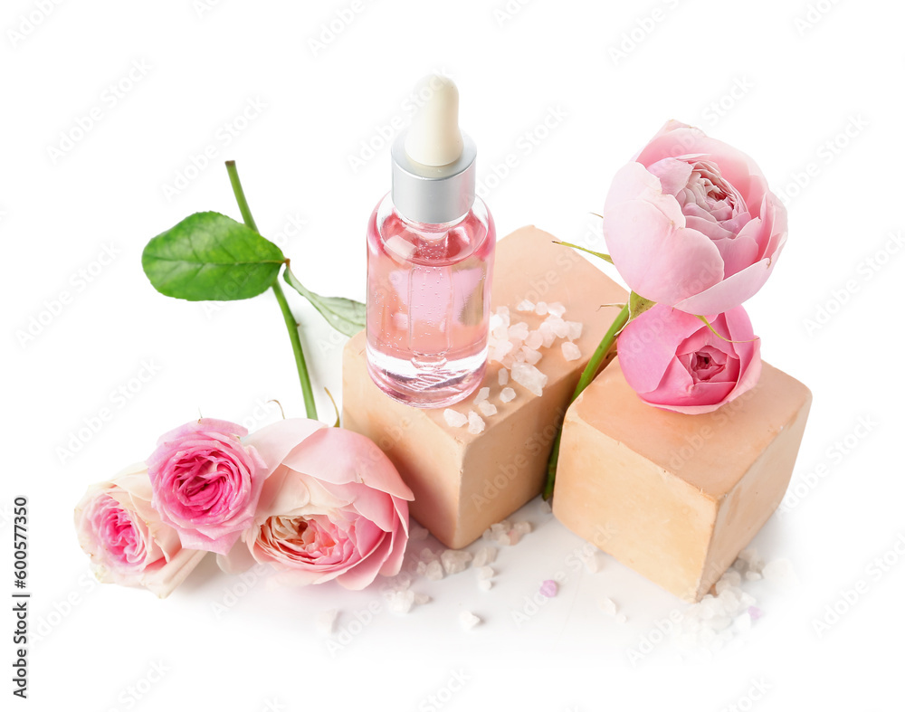 Bottle of cosmetic oil with rose extract and flowers on white background Bottle of cosmetic oil with rose extract and flowers on white background