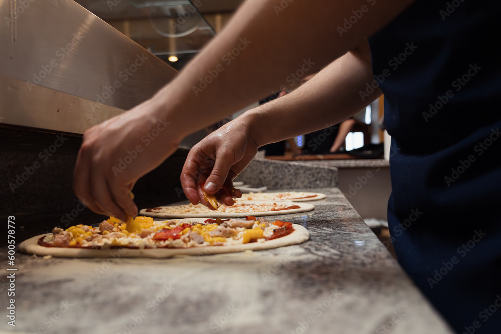 Food concept. Preparing traditional italian pizza. Chef in uniform in interior of modern restaurant kitchen. Ready to eat