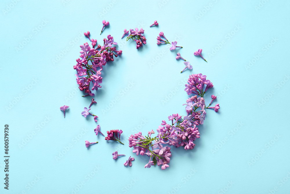 Frame made of blooming lilac flowers on blue background