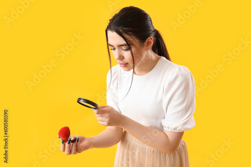 Young woman with magnifier ...