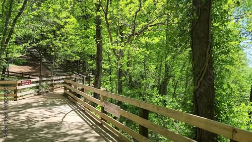 footage of a gorgeous spring landscape with lush green trees and plants and a flowing waterfall with large rocks at Amicalola Falls State Park in Dawsonville Georgia USA photo