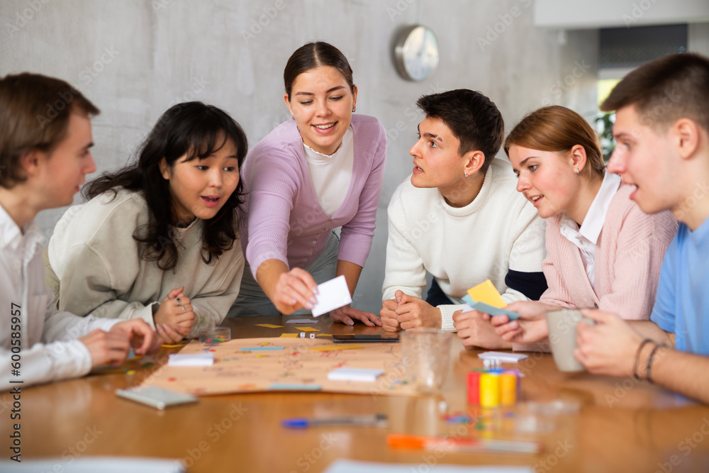 Group of positive younger people playing tabletop game Stock Photo