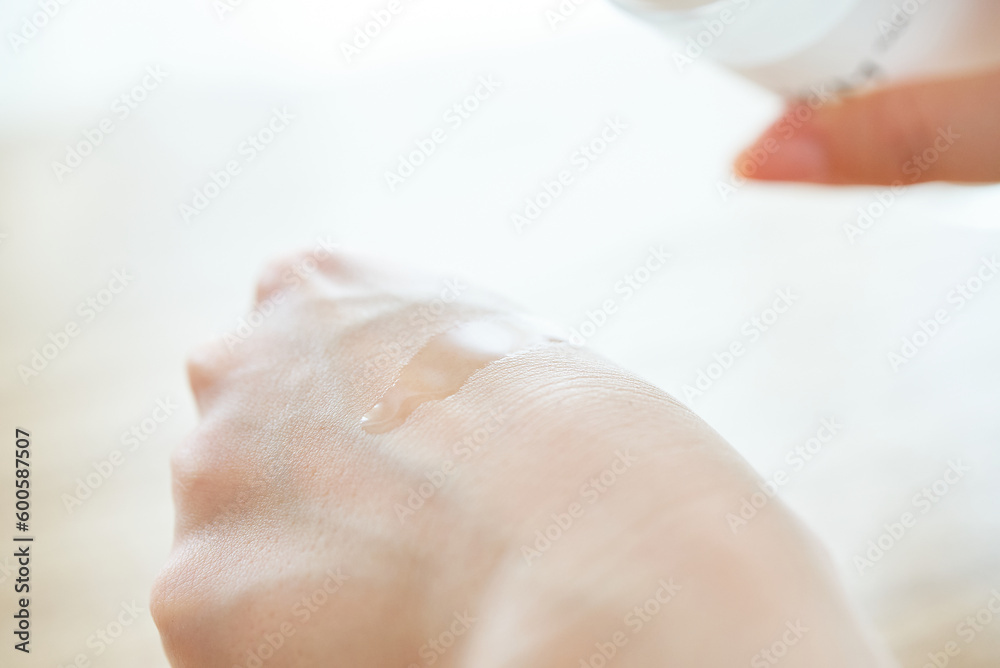 Naklejka premium 化粧水を手に乗せる女性の手元