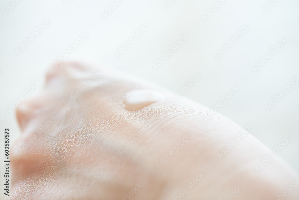 Fototapeta premium 化粧水を手に乗せる女性の手元