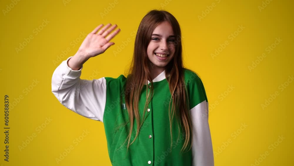 4k video of cute girl waving hello on yellow background. 4k video of cute girl waving hello on yellow background.