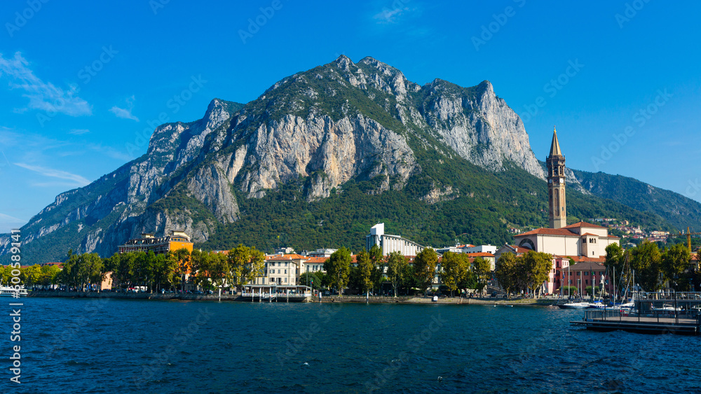Picturesque view of small city of Lecco on shore of Lake Como on background of San Martino mountain on summer day, Italy