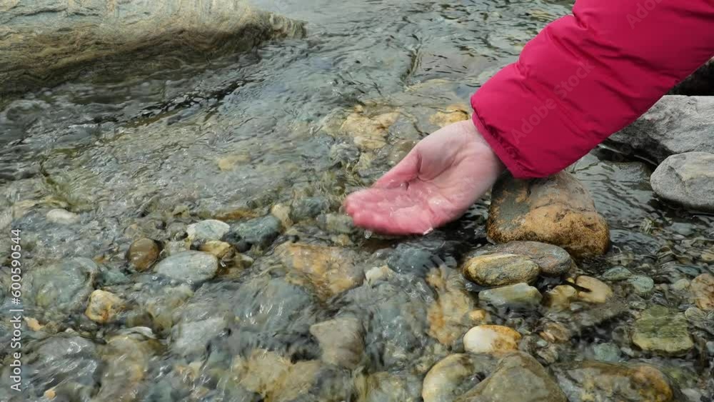 Clear water in a mountain stream. hand touches the pure water of the running stream.Water pours and drips from an open palm. splashes and drops. Clear water in a mountain stream. hand touches the pure water of the running stream.Water pours and drips from an open palm. splashes and drops.