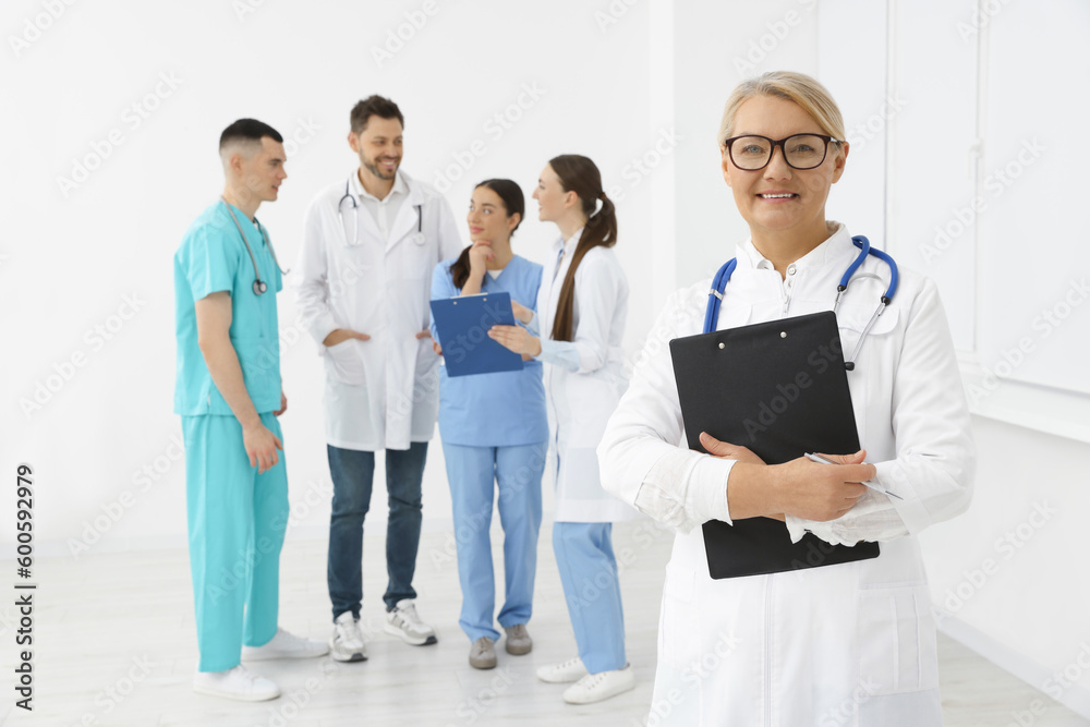 Portrait of doctor near colleagues in clinic Portrait of doctor near colleagues in clinic